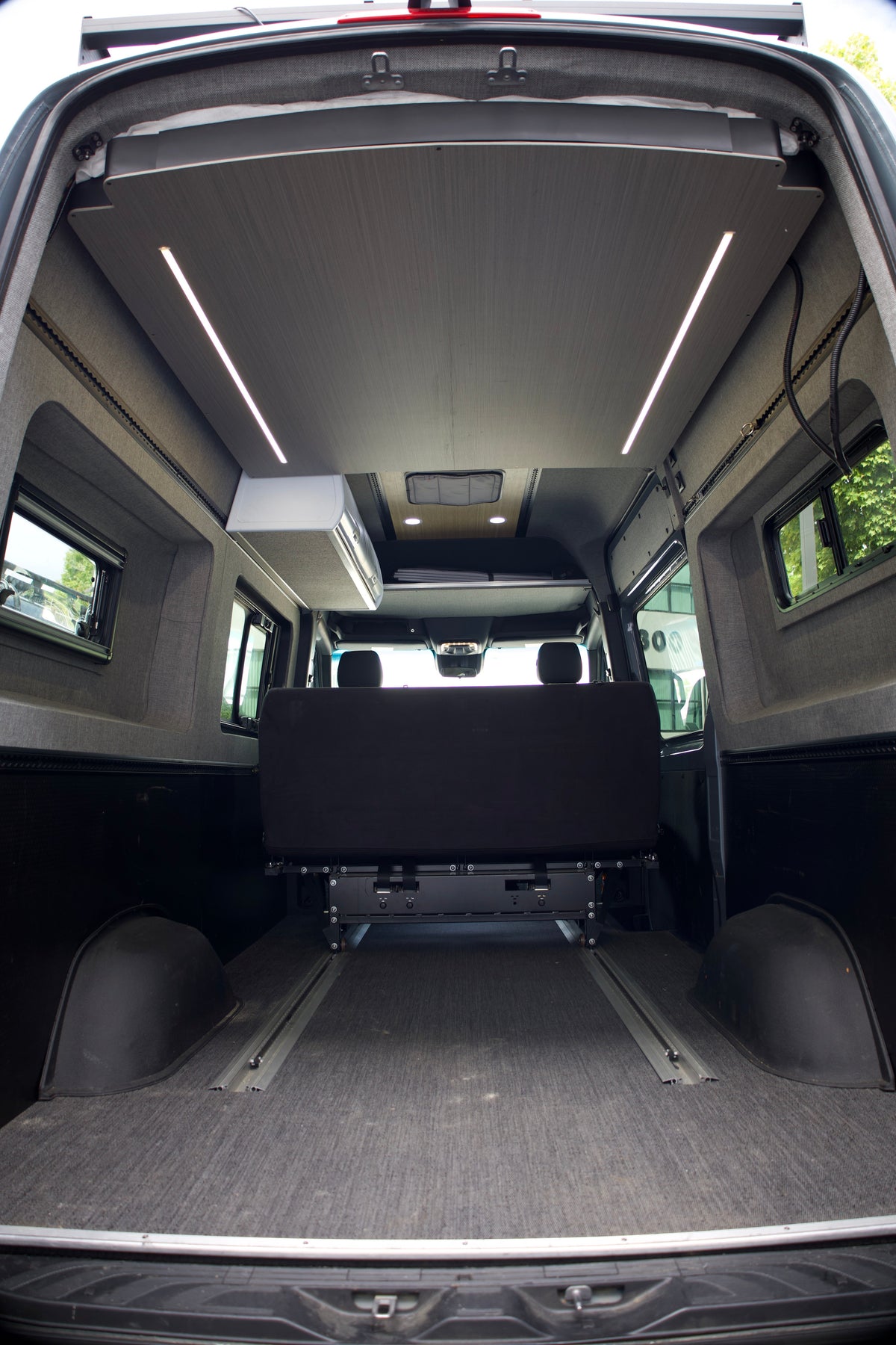 Camper van living space below the raised elevator bed