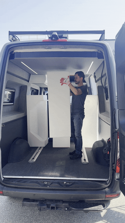 Animated RoamLabX camper van elevator bed showing the living space below the raised bed